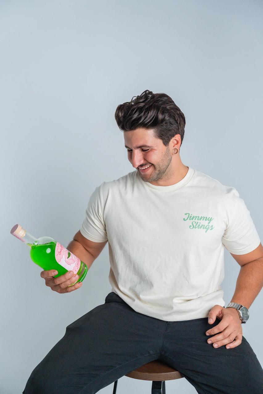 Jimmy in the Jimmy Slings tee, admiring a bottle of Greenbach
